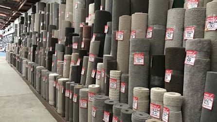 Rolls of carpet showing discounted pricing up to 50% off retail prices
