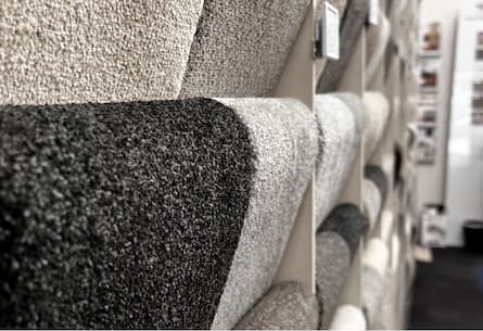 Rolls of carpet showing discounted pricing up to 50% off retail prices