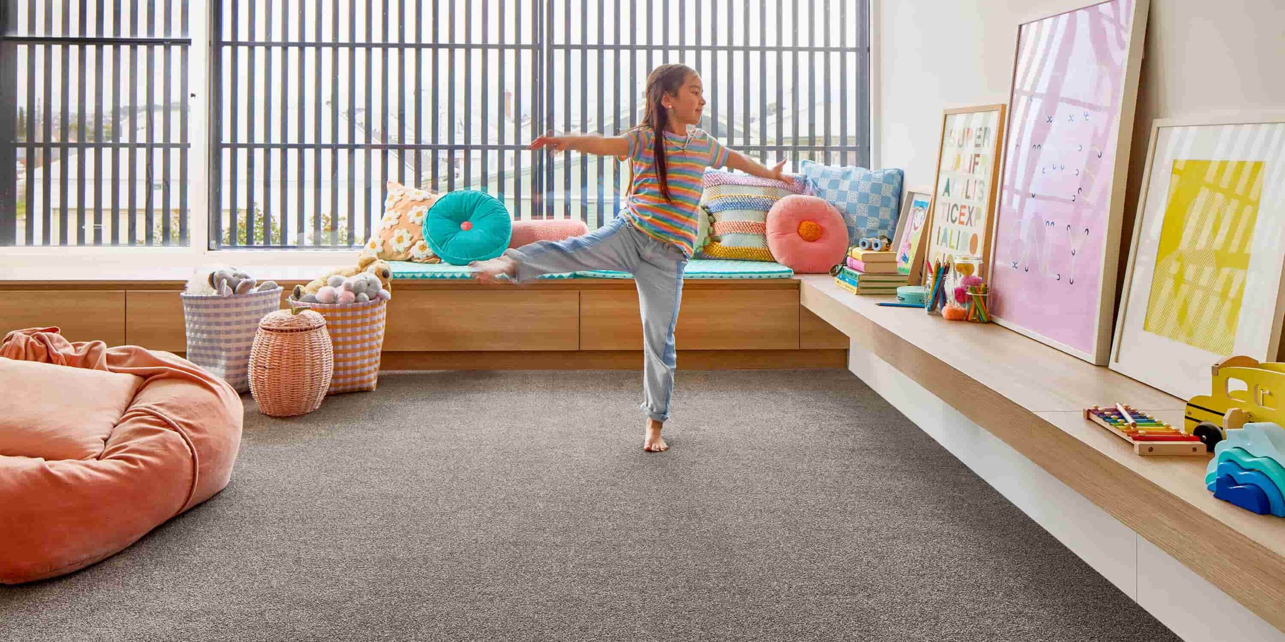 a girl standing on one leg in a room with pillows